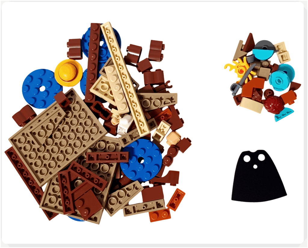 レゴ ONE PIECE 75636「フーシャ村」1袋目のパーツ。基礎プレートやブラウン系のブロック、青い円形タイル、小物パーツ、布製マントなどが含まれ、建物の土台や水辺の表現を組み立てる初期工程が分かる構成。