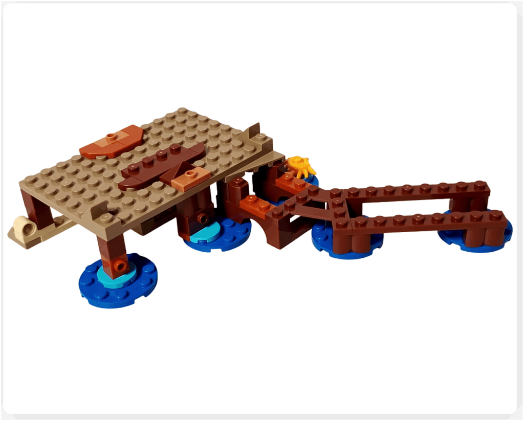 レゴ ONE PIECE 75636「フーシャ村」で、小屋の床部分と桟橋の基礎を接続した状態。砂浜色の建物床と青い水面タイルの上に伸びる桟橋が組み合わさり、海辺の生活感あるレイアウトが形作られている様子。