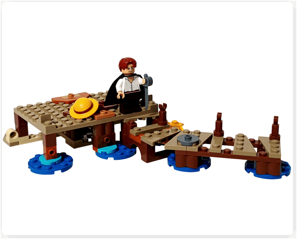 レゴ ONE PIECE 75636「フーシャ村」1袋目の組立完了状態。小屋の床や砂浜、桟橋の基礎が仕上がり、海辺の情景がはっきりと形成されている。シャンクスのミニフィグを置くことで、村の日常の雰囲気が伝わる様子。