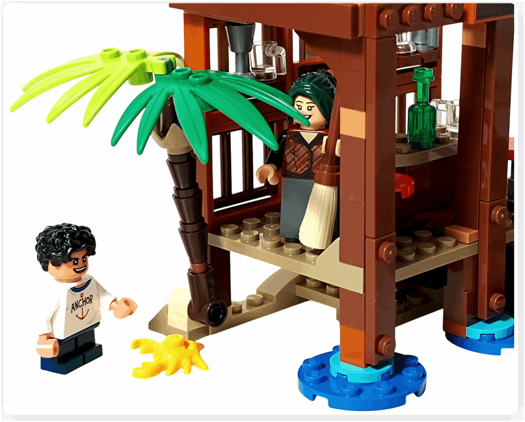 レゴ ONE PIECE 75636「フーシャ村」の情景。外でカニと遊ぶ子供ルフィと、店先から箒を持って静かに見守るマキノが描かれ、フーシャ村の素朴で温かな朝の空気が伝わるシーン。