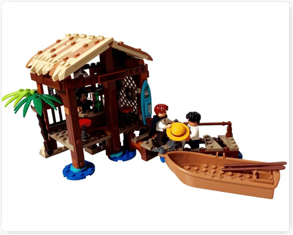 レゴ ONE PIECE 75636「フーシャ村」の完成シーン。桟橋でシャンクスが麦わら帽子をルフィに手渡し、手前には小舟が停泊。小屋の中ではマキノが見守り、東の海の穏やかな空気と物語の始まりを象徴する情景が再現されている。