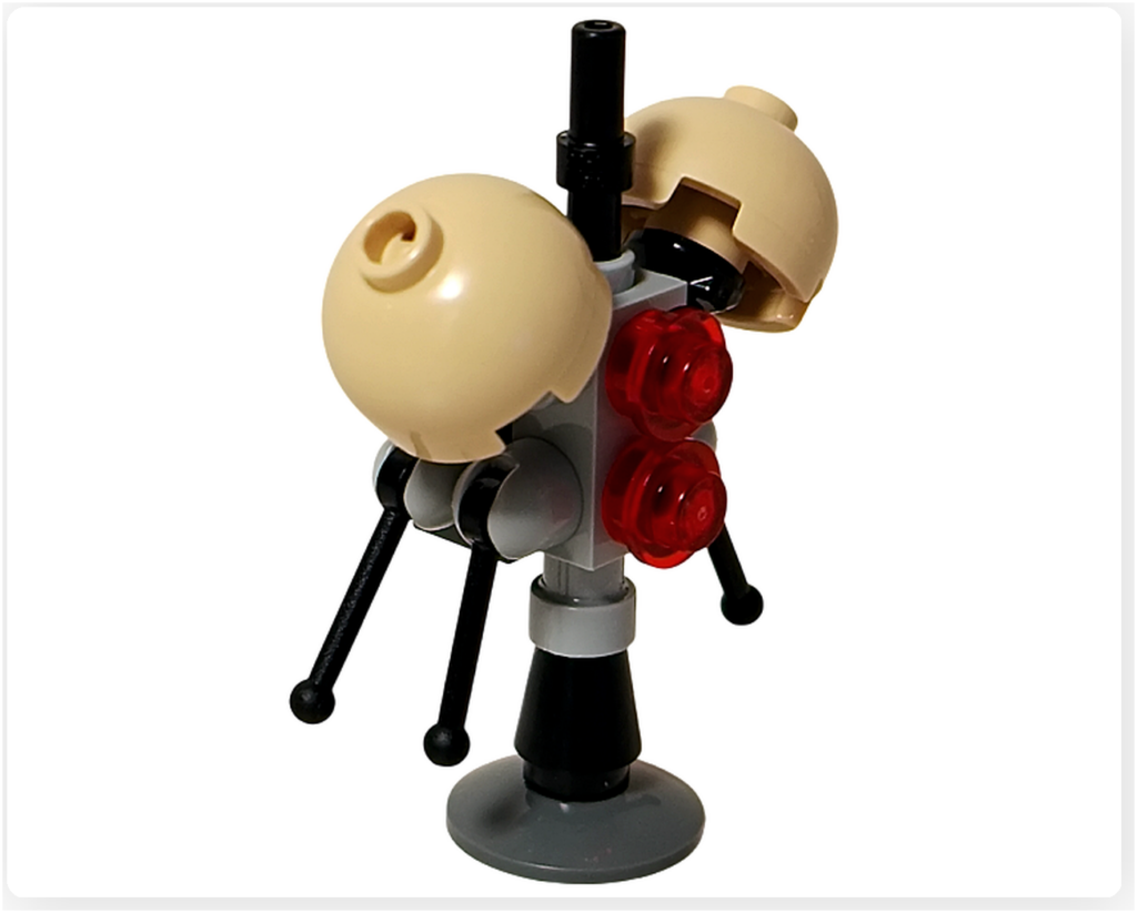 LEGO スター・ウォーズ 75418 アドベントカレンダー2025に含まれるバズ・ドロイドを右側面斜め前から撮影した写真。ベージュの半球状パーツ、前面に配置された赤い円形パーツ、グレーの支柱構造と黒いアームの接続状態が確認できる。